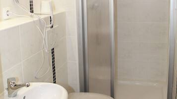 A bathroom with a toilet, sink, and shower.