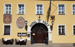 Fachada de hotel com entrada destacada, várias janelas e uma placa com o nome do estabelecimento.