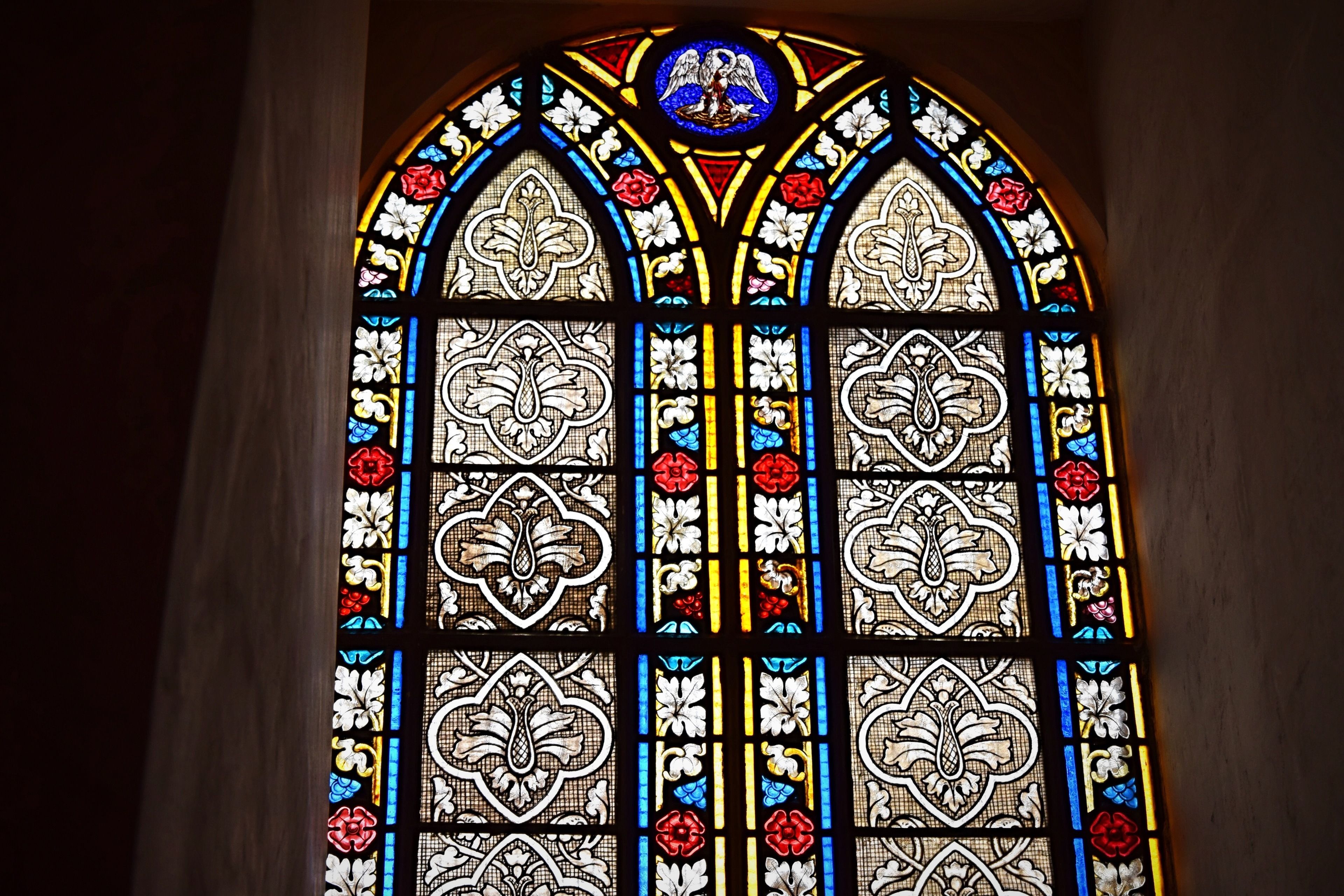 Un vitrail orné de motifs floraux et géométriques complexes.