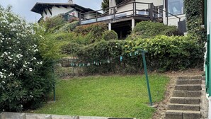 Un quartier résidentiel avec une clôture en bois, une pelouse verdoyante et un barbecue.