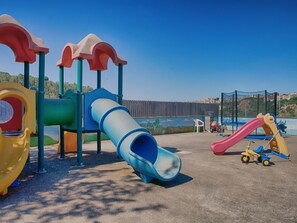 Explore the playground with slides and climbing elements, offering a fun space for kids to play.