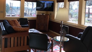 Un salon avec un téléviseur, une lampe et un canapé.