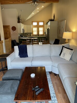 Relax in this stylish living space with a sofa, dining table, and kitchen area.