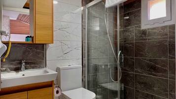 Een badkamer met toilet, wastafel en douche.