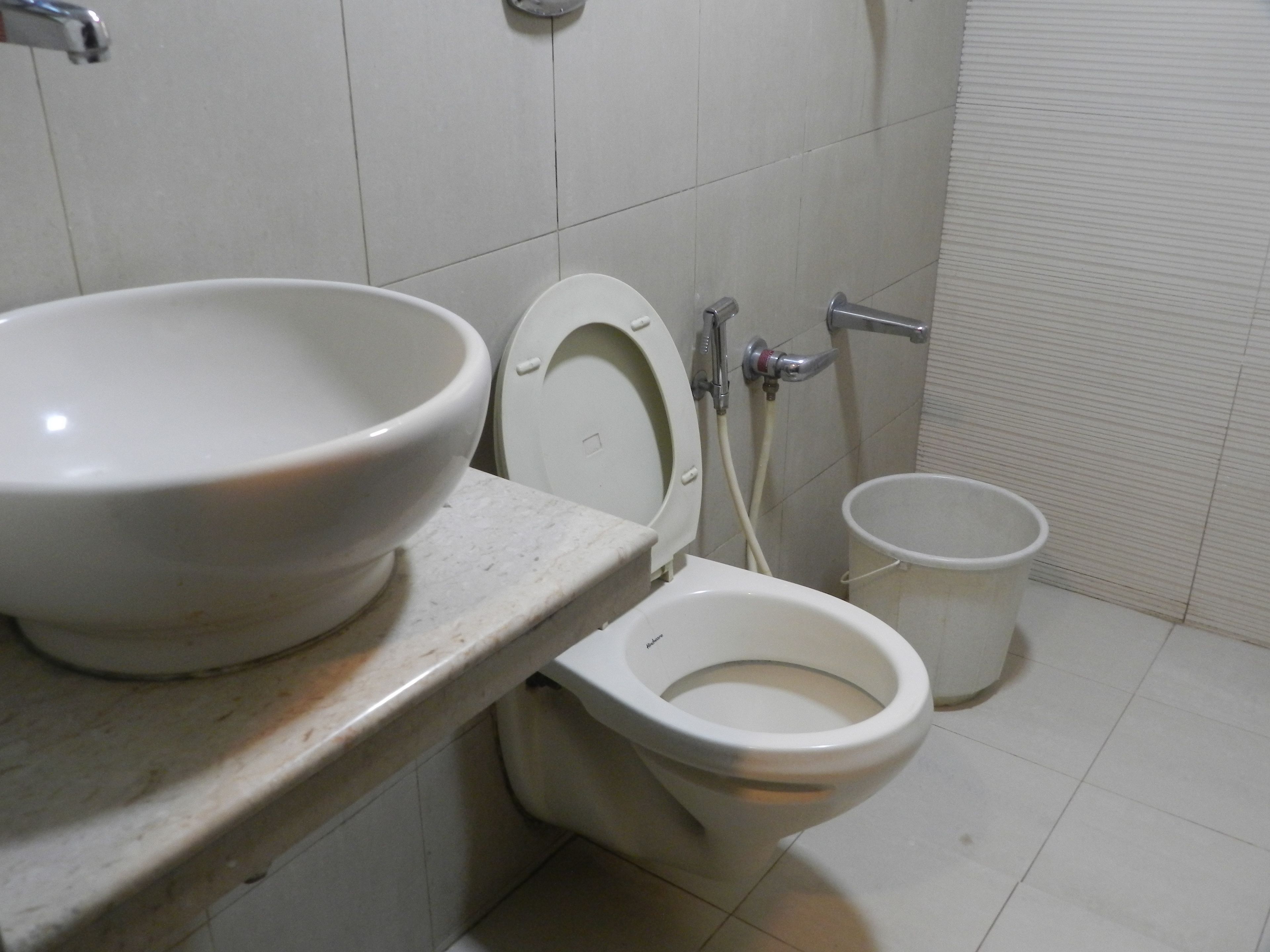 A bathroom with a toilet, a sink, and a bidet.