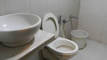 A bathroom with a toilet, a sink, and a bidet.