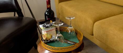 A wooden tray with a bottle of wine, a glass, and a box of Brettes Classics on a table.