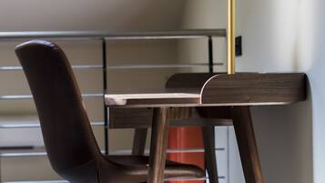 Una silla con respaldo alto y una mesa de madera con estructura metálica.
