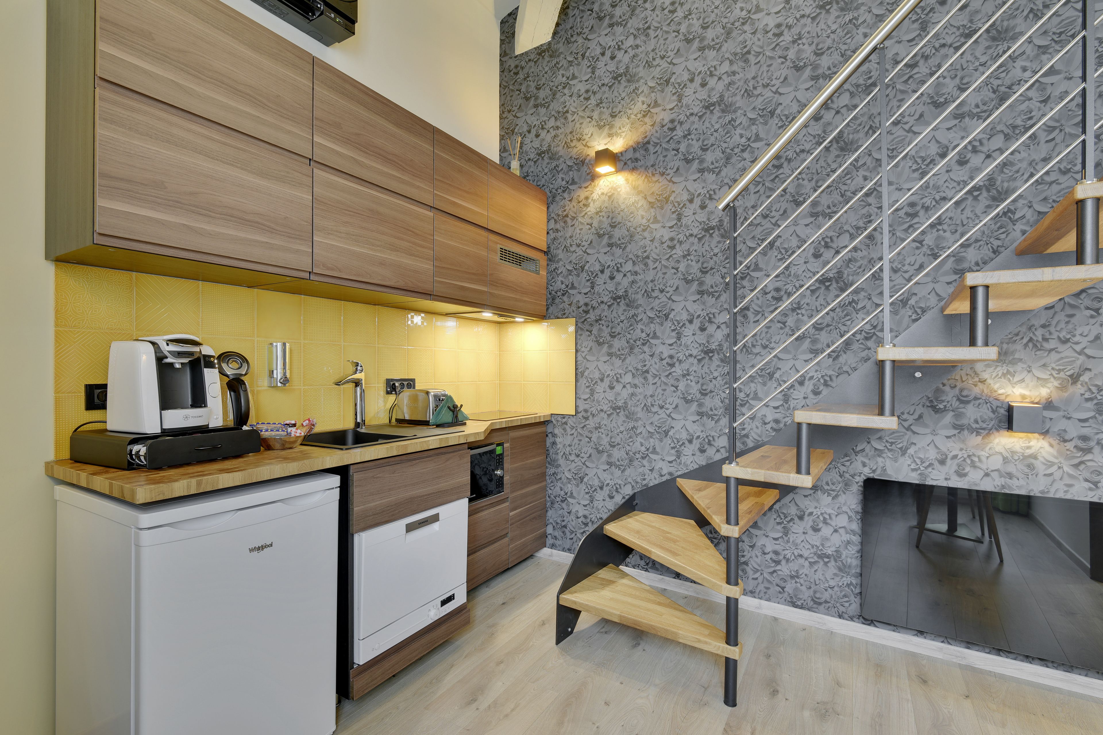A modern kitchen with wooden cabinets, a built-in dishwasher, and a compact countertop.