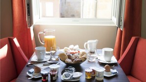 Une table de petit-déjeuner avec divers aliments, boissons et condiments.