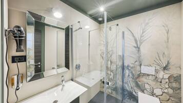 Een moderne badkamer met een douchecabine van glas, een grote spiegel en een wastafel.