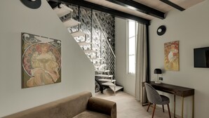 Un intérieur moderne avec un escalier, un canapé, un bureau et des œuvres d’art.