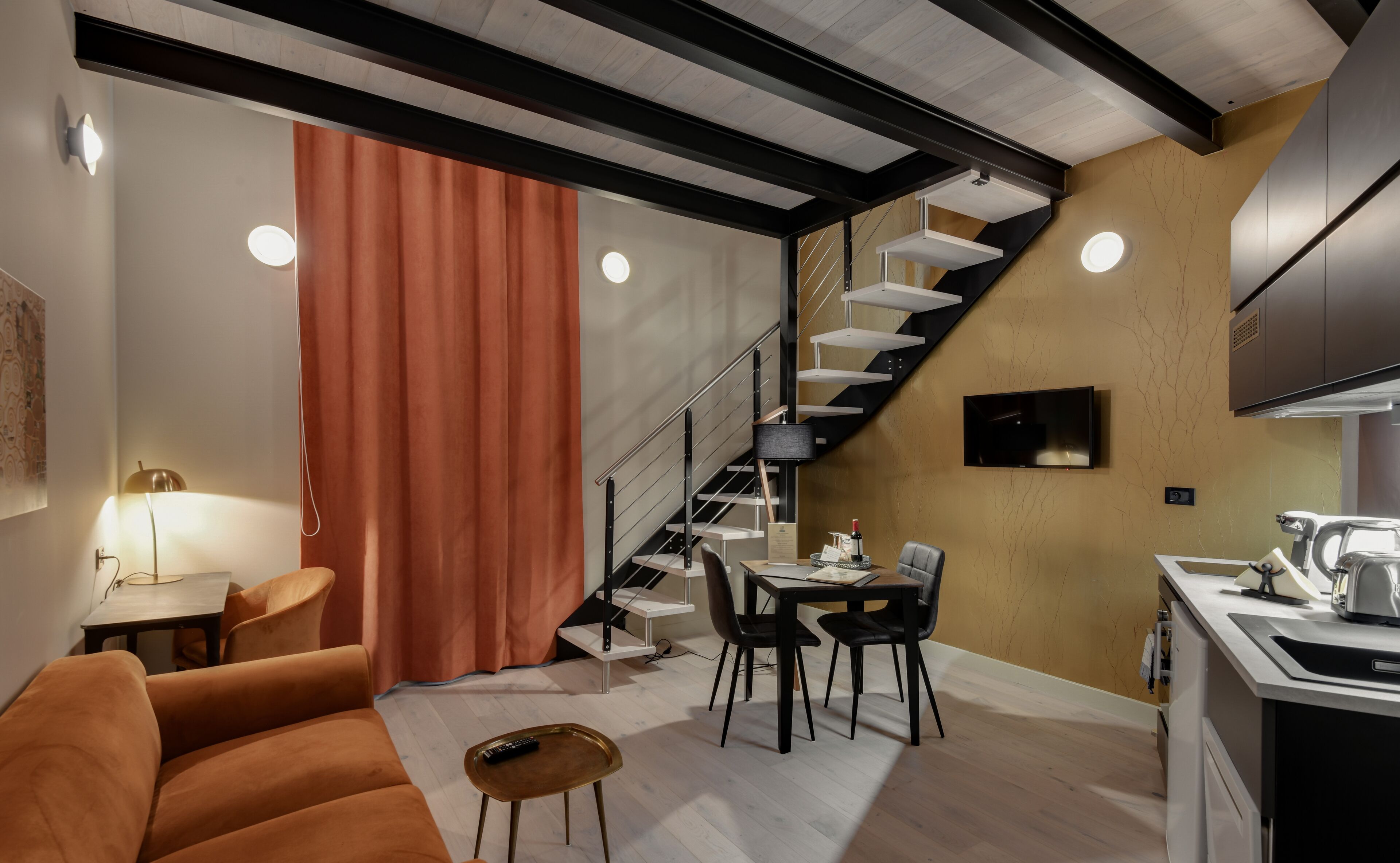 Un apartamento moderno con una escalera, un comedor y una cocina.