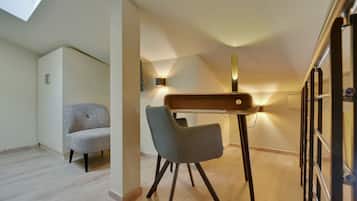 A modern, well-lit room with a wooden desk, two chairs, and a ceiling light.