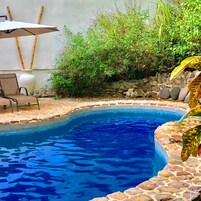 Una piscina al aire libre, sillones reclinables de piscina