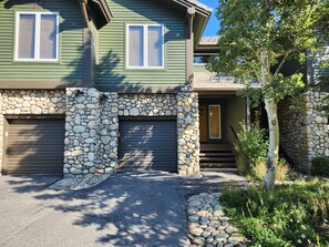 A two-story house with a stone facade, a garage, and a front porch.