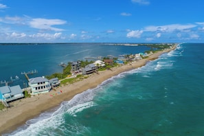 A coastal property with a beach, ocean view, and a pier.