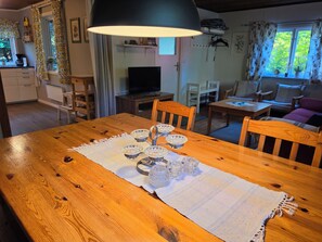 A wooden dining table with a white table runner and crystal glassware. - Cozy cottage near the lake, including free Wi-Fi and own rowing boat (Hallaryd)