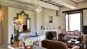 A cozy living room with a fireplace, a large mirror, a bookshelf, and a comfortable seating area.