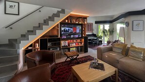 Uma sala de estar moderna com uma escada que dá acesso a um mezanino.
