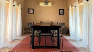 Un espace repas comprenant une table, des chaises et un lustre.