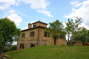Traditional stone building with a central entrance and two flanking windows.