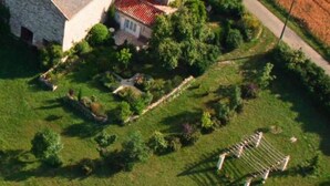A large stone building with a red-tiled roof, surrounded by lush greenery and a well-maintained lawn. - Country Cottage / Gite - LOUBERS (Loubers)