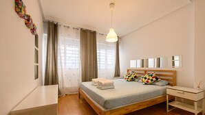 A neatly arranged bedroom with a bed, bedside table, and a hanging light fixture. - Downtown Madrid North Barrio del Pilar. Tempory (Madrid)
