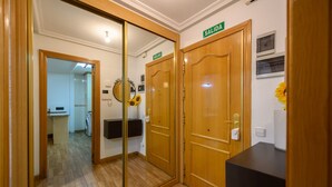 A hotel room with a wooden floor, a mirror, a reception desk, and a sign indicating the room number. - Downtown Madrid North Barrio del Pilar. Tempory (Madrid)