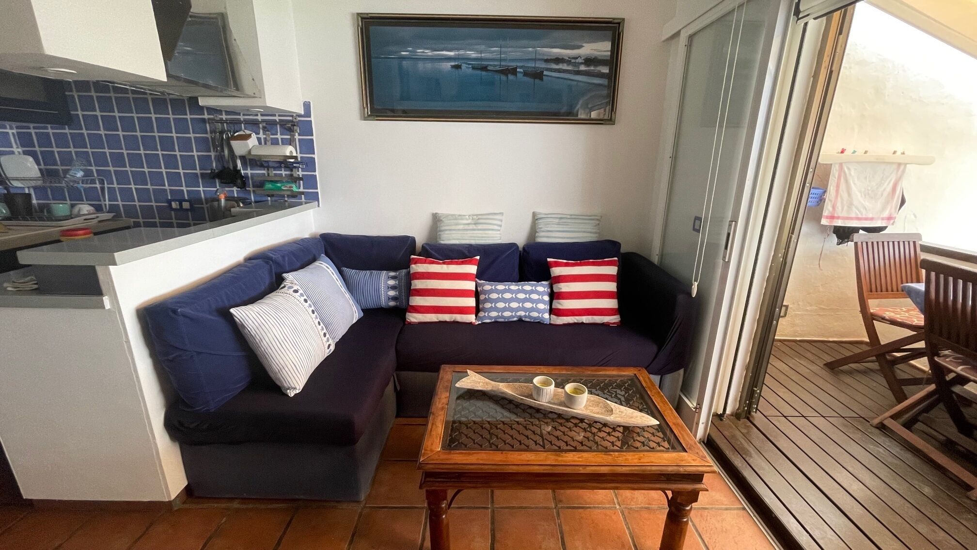 Un espacio habitable pequeño con un sofá, una mesa de centro y vistas al puerto a través de una ventana.