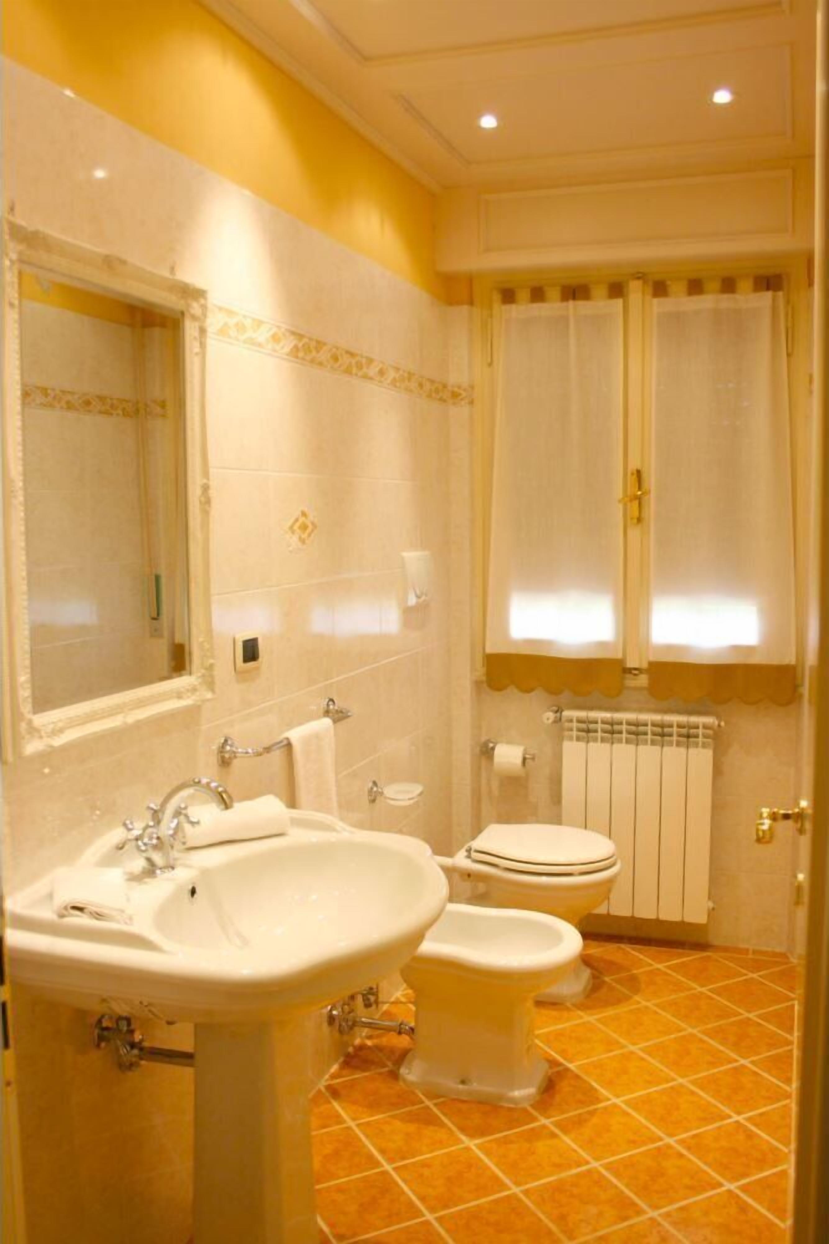 Une salle de bain avec un lavabo, des toilettes et un miroir.