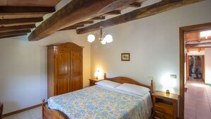 Una camera da letto con un letto di legno, un comodino, un armadio e un lampadario.