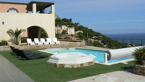 A rooftop pool area with lounge chairs, a hot tub, and a view of the sea and surrounding buildings. - House / Villa - MONTICELLO (Monticello)