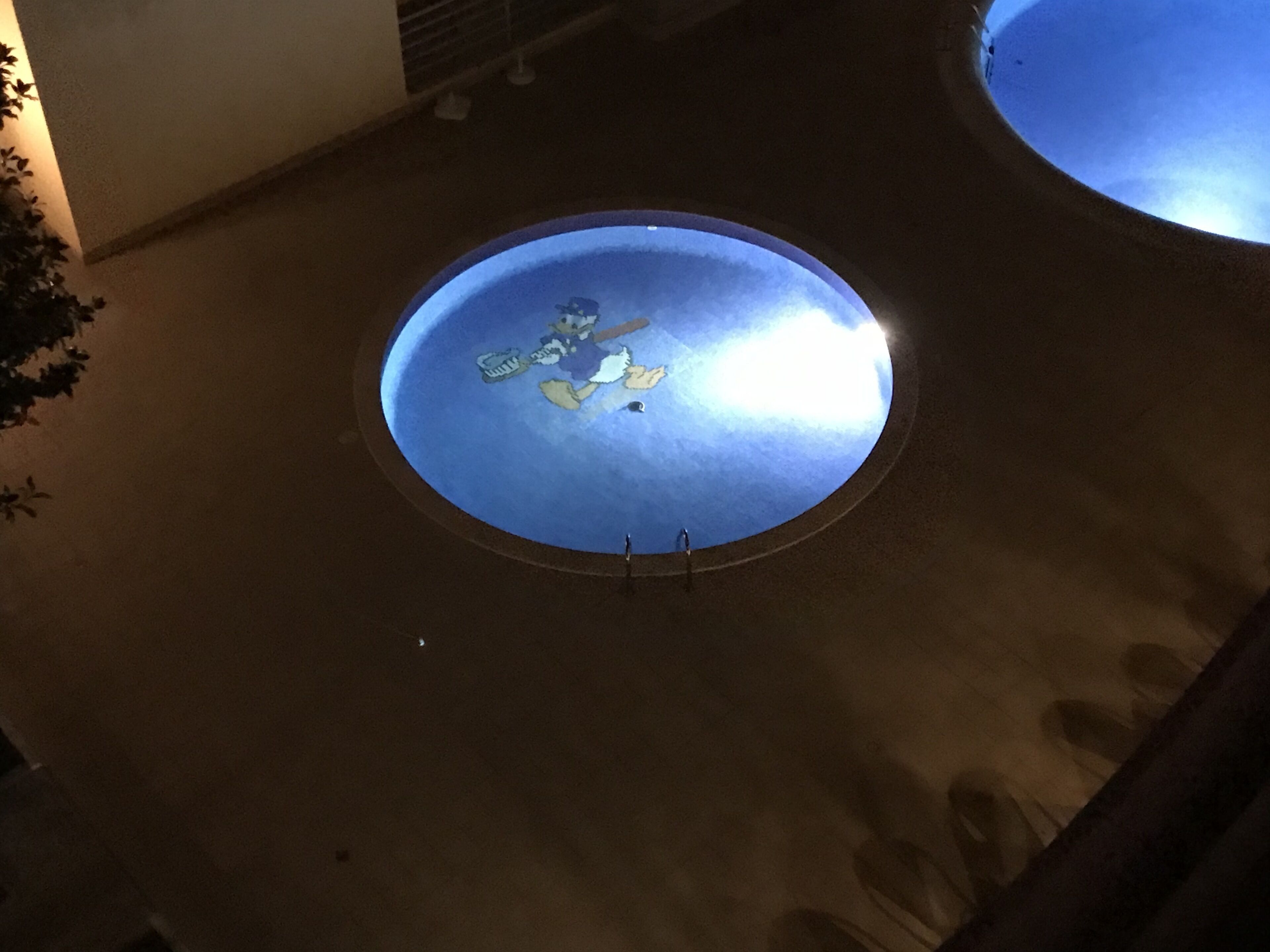 Une lucarne circulaire dotée d’une surface réfléchissante, entourée d’une structure en béton.