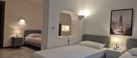 A hotel room with a bed, two bedside tables with lamps, a mirror, and a framed picture on the wall.
