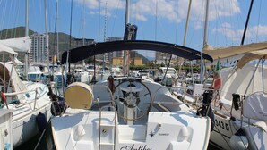 A marina with multiple sailboats docked, featuring a prominent "Antibes" sign on the bow of one boat.