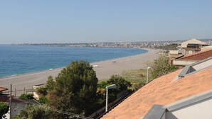 Vista costera con playa, edificios y cielo despejado.