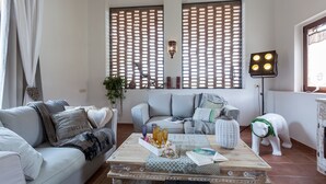 Ein Wohnzimmer mit einem hellblauen Sofa, einem Couchtisch aus Holz mit Dekoration und einer weißen Statue.