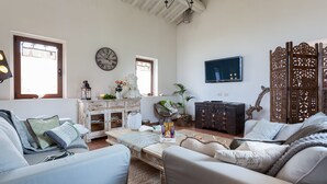 Ein Wohnzimmer mit einer Couch, einem Couchtisch, einem Fernseher und einem dekorativen Holzverkleidung.