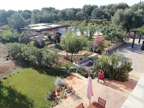 A garden with a pool, outdoor seating, and a pergola.