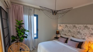 Une chambre à coucher comprenant un lit, une plante en pot, une chaise et un luminaire au plafond au design original.