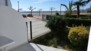 A balcony with a view of a beach and palm trees. - Nice apartment in front of the sea in Roses Inmosantos Oasis E3 (Rosas / Roses)
