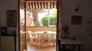 A room with a dining area, a kitchen, and a view of the outside. - Apartment/ flat - Marina di grosseto (Marina di Grosseto)