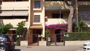 A multi-story building with a central entrance, balconies, and a tree in front. - Apartment/ flat - Marina di grosseto (Marina di Grosseto)