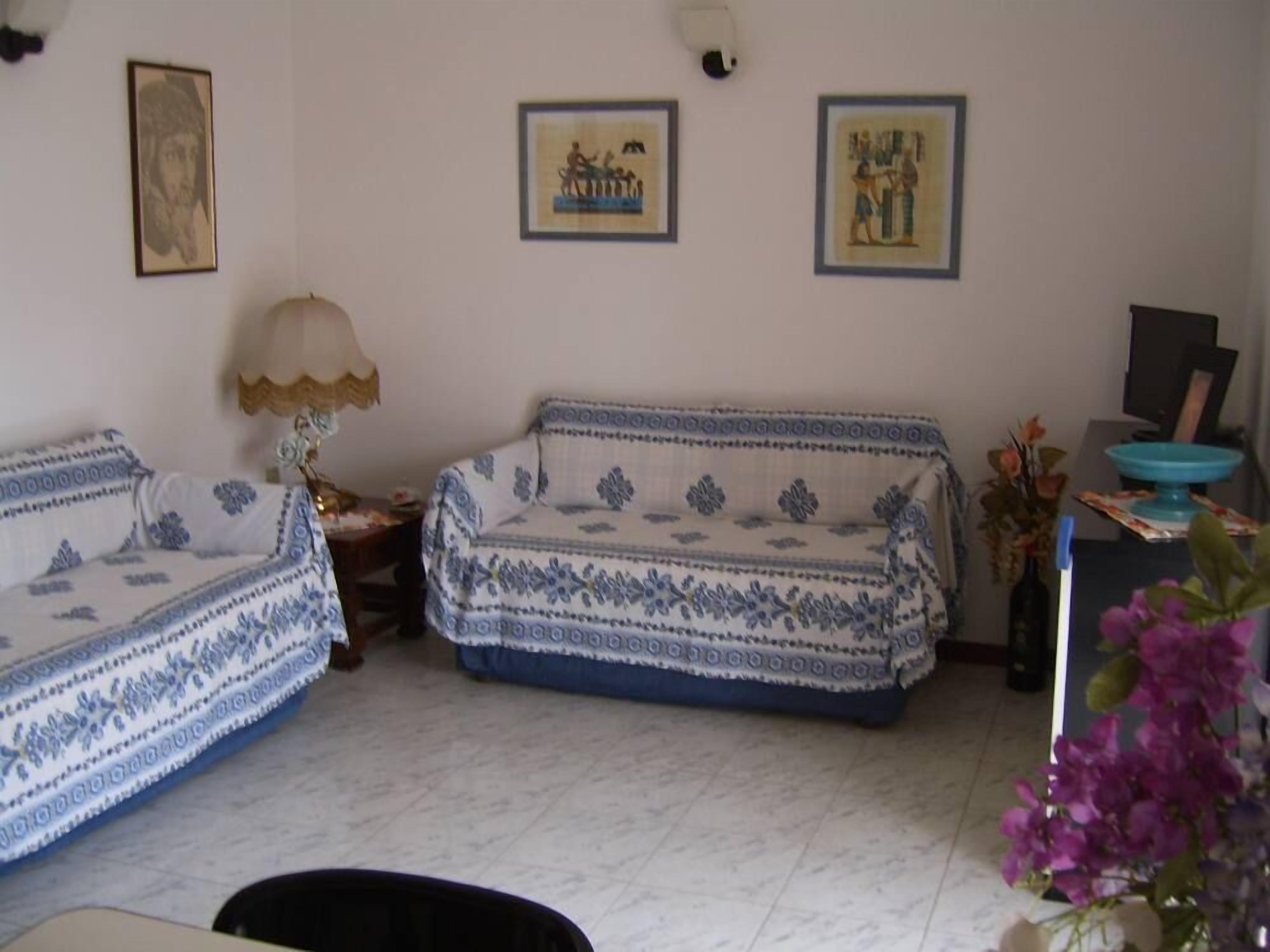 A living room with two sofas, a lamp, and framed pictures on the wall.