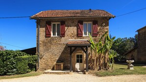 A stone building with a tiled roof, red shutters, and a small porch. - Beautiful villa for 4 people with private pool   (Urval)
