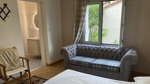 A bedroom with a bed, a sofa, a chair, a window, and a door. - Spacious 8-Bed Villa; Pool, Mountain Views, Easy Access to Céret, Coast & Spain (Céret)