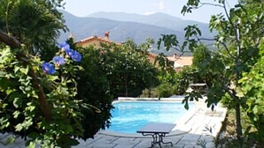 A swimming pool surrounded by lush greenery and a view of distant mountains. - Spacious 8-Bed Villa; Pool, Mountain Views, Easy Access to Céret, Coast & Spain (Céret)