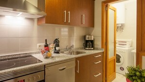 Una cocina moderna con estufa integrada, cafetera y pileta.