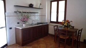 Una cocina con una isla central, armarios de madera, una mesa de comedor con sillas y una ventana con vistas.